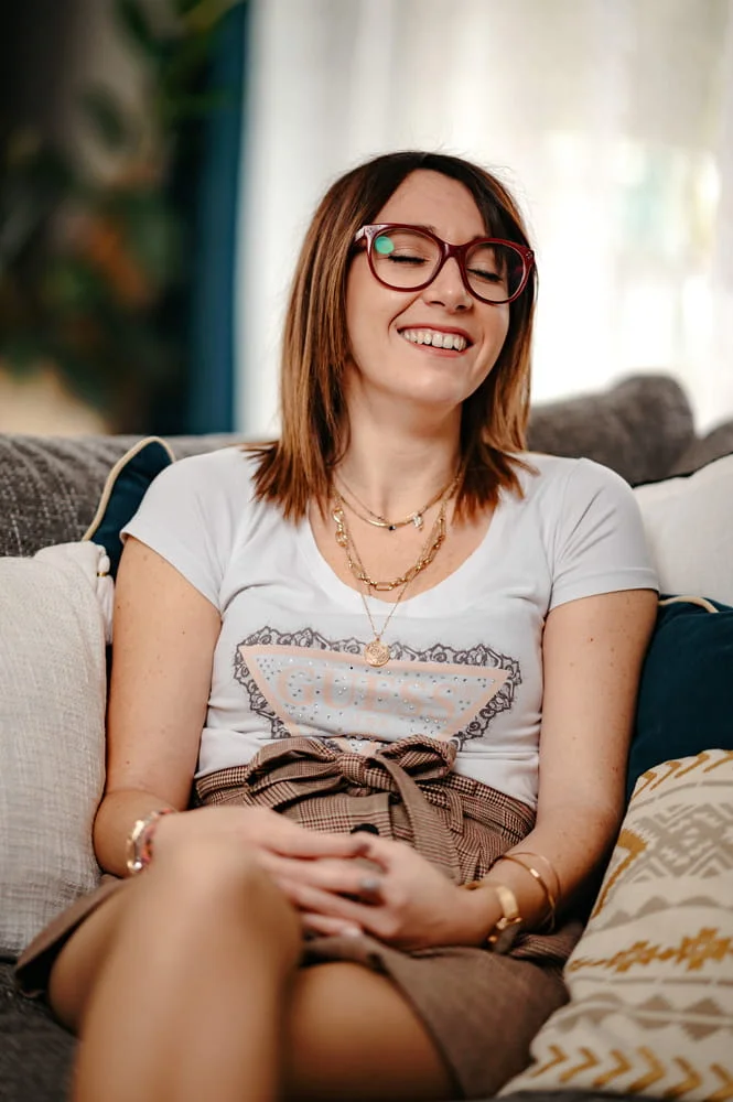 Mélanie, rédactrice web SEO, assise sur un canapé, souriante et détendue.